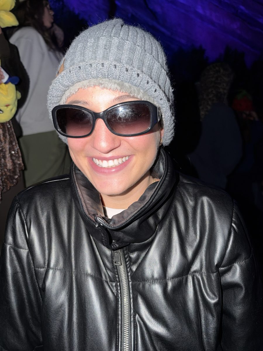 Jordy in a grey beanie, sunglasses, and a black leather jacket with a huge smile.
