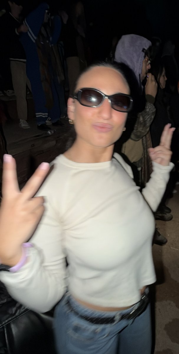 Jordy in sunglasses throwing two peace signs with a kissy face.
